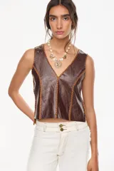 Chaleco de cuero color marrón con cuello en V, sin mangas, detalles de costuras trenzadas en contraste y espalda tejida.