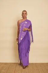 Vestido largo morado de un solo hombro con diseño de inspiración española, que incluye un mantón de Manila incorporado con bordados florales y flecos largos colgantes.
