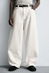 Jeans de denim de algodón color negro, con corte balloon fit relajado desde la cadera y ligeramente estrechado en el bajo. Tiro medio, cinco bolsillos y cierre frontal con cremallera y botón.