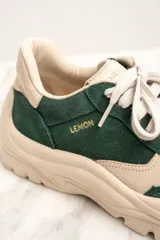 Zapatillas deportivas de gamuza verde con detalles en cuero color crema, cordones blancos y suela chunky color crema.