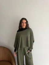 Conjunto de dos piezas de lanilla en color gris melange, compuesto por una blusa de corte amplio con mangas murciélago y escote bote, y un pantalón recto con bolsillos laterales.
