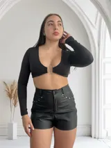 Short negro de cuero sintético con tachas plateadas en los laterales.