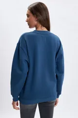 Buzo de algodón azul con cuello redondo, corte oversize y diseño bordado frontal con estilo universitario que incluye el texto Los Angeles y el número 58.