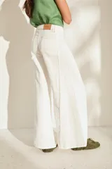 Pantalón de lino blanco de corte wide leg, con diseño amplio y costuras pespunteadas a contratono.
