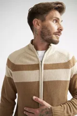 Campera tejida de algodón con diseño color block en tonos beige y marrón. Presenta cierre frontal completo, cuello alto y textura acanalada.