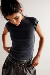 Remera de punto acanalado gris oscura, de calce entallado y largo a la cadera, con escote redondo, mangas cortas tipo casquillo y costuras en relieve.
