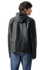 Campera de cuero sintético negro con capucha gris incorporada, bolsillos frontales con cierre y detalles acolchados en los hombros y mangas.