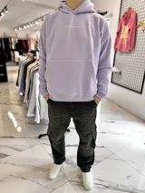 Canguro oversize lila con capucha y gran estampado blanco en la espalda con la palabra "LOVE" y un imperdible.
