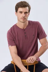 Remera básica de manga corta y cuello redondo, color bordó, con cartera de botones en el pecho y pequeño bordado al tono.