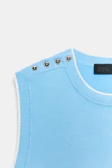 Jersey de punto azul marino sin mangas, con cuello redondo, ribetes en contraste y detalles de botones dorados en el hombro.