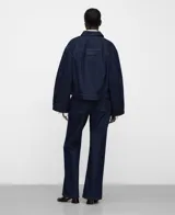 Chaqueta boxy denim de algodón orgánico y reciclado, color azul, con cuello italiano, mangas largas amplias, botonadura frontal y bolsillos delanteros con doble entrada.