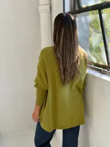Sweater de punto color verde pistacho, con cuello redondo, mangas largas con puños ajustados y diseño holgado de corte oversize.