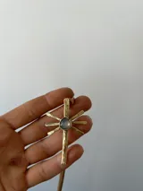Gargantilla con cordones de gamuza marrón y dije de sol dorado con piedra de ágata en el centro.
