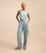 Pantalón wide de jeans celeste, con cintura con trabillas, cierre tradicional y bolsillos cargo laterales.