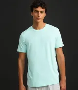 Remera deportiva de hombre con tecnología dry fit, cuello redondo y manga corta. Presenta un diseño liso en color beige con una pequeña etiqueta decorativa en el dobladillo.