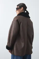 Tapado de efecto cuero negro con interior y detalles de cuello y puños en pelo sintético. Presenta un diseño envolvente con cierre frontal de botones y bolsillos laterales.