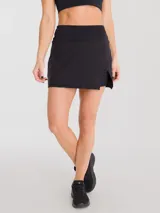 Falda deportiva negra con calza interior y bolsillo lateral. Diseño cruzado en la parte frontal.