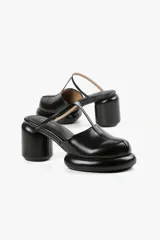 Mules de cuero color blanco con diseño moderno, taco ancho y plataforma. Cuenta con una tira superior negra que aporta estabilidad y un calce cómodo.