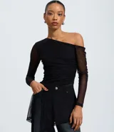 Blusa ajustada de tul negro con diseño asimétrico de un solo hombro. Presenta mangas largas transparentes, fruncido lateral y una aplicación vertical de encaje que aporta textura.