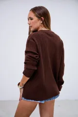 Sweater de punto acanalado color marrón chocolate, con cuello redondo y mangas largas con puños ajustados.