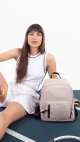 Mochila de nylon color verde oliva, con cierre principal y dos bolsillos frontales con cierre. Tiene correas de hombro ajustables en color negro y asa superior de agarre.