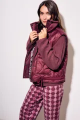 Chaleco bordeaux con interior estampado floral, de corte al cuerpo y cierre frontal con cremallera.