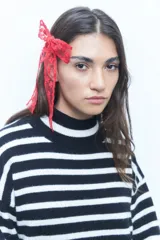 Broche para el pelo con forma de moña confeccionada en encaje color rojo.