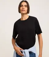 Blusa básica lisa de algodón color negro, con cuello redondo y mangas cortas, de corte clásico y versátil.