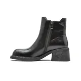 Bota tipo chelsea de cuero color marrón oscuro con acabado desgastado. Presenta paneles elásticos laterales decorados con tachas metálicas doradas, puntera cuadrada y taco bloque de altura media con textura amaderada.