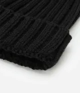 Gorro de punto acanalado color tostado, con diseño clásico de vuelta y pompón de pelo sintético en la parte superior.