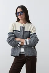 Cardigan de tejido jacquard en color azul marino y blanco, con diseño de conejitos en los laterales, cierre frontal con botones y cuello redondo.