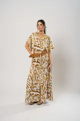 Vestido largo con estampado animal print en tonos camel, blanco y negro. Tiene escote en V, mangas cortas tipo murciélago y tajo frontal. Incluye cinturón ancho de cuero color camel.