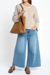 Remera de manga larga con cuello redondo, confeccionada en algodón con elastano. Presenta un diseño de rayas horizontales en color azul marino sobre fondo blanco.