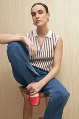 Jean de corte recto confeccionado en denim con spandex, de tiro medio y color azul claro. Presenta un tajo lateral en el ruedo de ambas piernas.