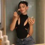 Body negro sin mangas, con cuello alto y diseño de aberturas laterales y frontales (cut-out).