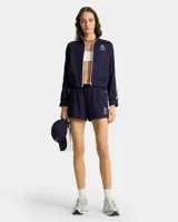 Short deportivo azul marino con cintura elástica ajustable con cordón, logo bordado en blanco y rayas laterales blancas.