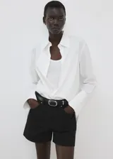 Short de denim negro de tiro medio con diseño de cinco bolsillos, presillas para cinturón y cierre frontal con botón y cremallera.