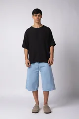 Remera de corte oversize confeccionada en tejido texturado tipo lino, de color beige, con cuello redondo amplio y mangas cortas de calce relajado.