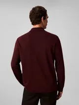 Chomba de manga larga Calvin Klein confeccionada en algodón interlock, con cuello clásico, cartera con botones y logo de la marca bordado en el pecho.