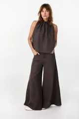 Blusa de lino italiano color marrón oscuro, con corte en línea A, hombros descubiertos, escote halter con frunces y volado en el cuello.