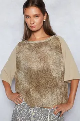 Remera de silueta boxy con estampado animal print, cuello redondo, bolsillo frontal y mangas 3/4 con terminaciones sin costura.