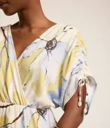 Vestido evasê midi de viscolino con estampado floral, escote en V cruzado, mangas cortas con lazos y corte en la cintura.