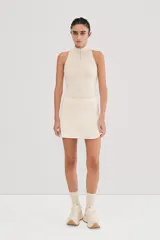 Falda de tenis color crudo con short interno, confeccionada en tejido de alta torsión.