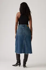 Falda midi de jean azul con corte en A, tiro alto, cierre frontal con botones y ruedo desflecado.