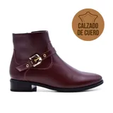 Bota corta de cuero color borgoña, con hebilla dorada y taco bajo.