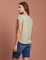 Blusa color beige de modal con escote en V, abertura central con botones y ruedo anudado. Marca French Laundry.