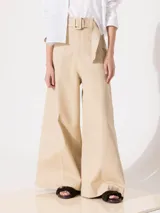 Pantalón de tiro alto color beige, de corte palazzo, con cinturón con hebilla forrada, bolsillos diagonales delanteros y bolsillos sastre traseros.