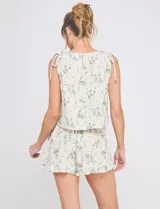 Short de lino y viscosa color beige con estampado botánico en tonos verde agua, tiro alto con cintura elastizada, corte holgado y ruedo con volado fruncido.