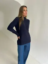 Polera de tejido de punto color azul, con cuello alto, mangas largas y tajos laterales en el ruedo.
