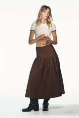 Falda midi marrón de tiro alto con pliegues marcados en la parte superior que caen en un vuelo amplio.